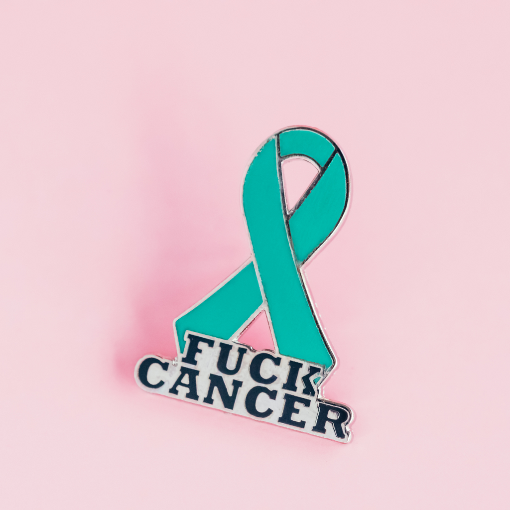 White awareness ribbon on top of fuck cancer enamel pin on white backgroud