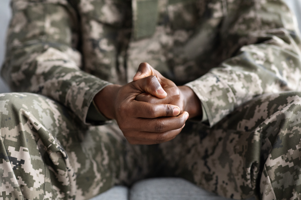 A black military man with his hands crossed