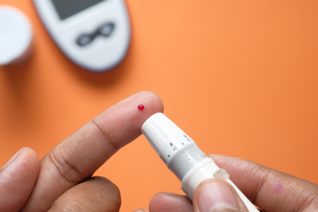 Finger with a drop of blood for a diabetes blood draw
