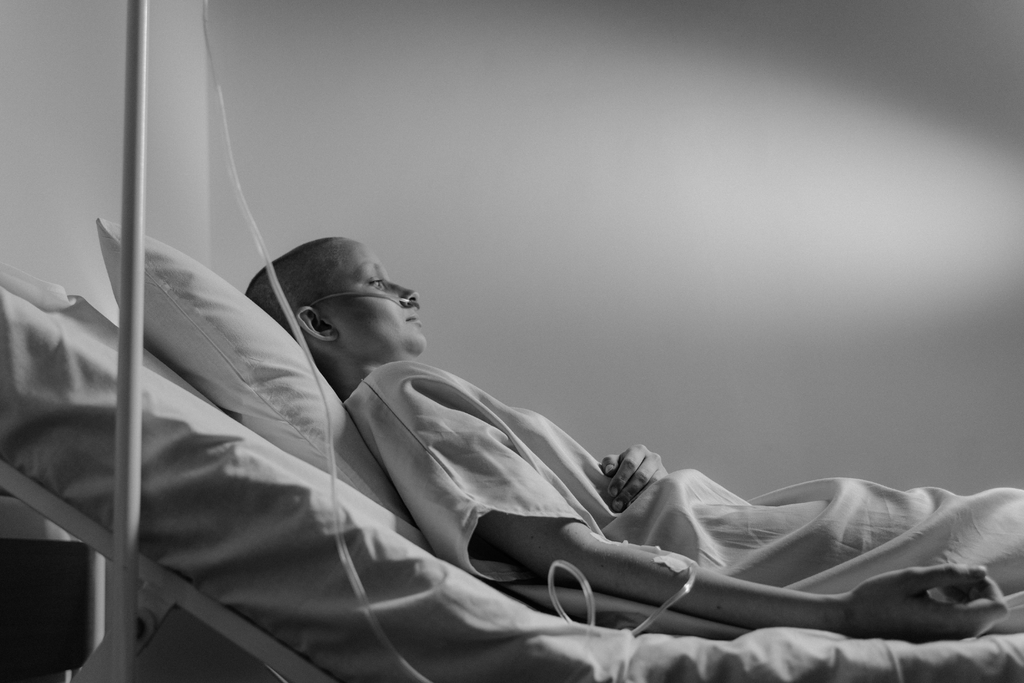 a woman patient hooked up to an iv laying on a hospital bead