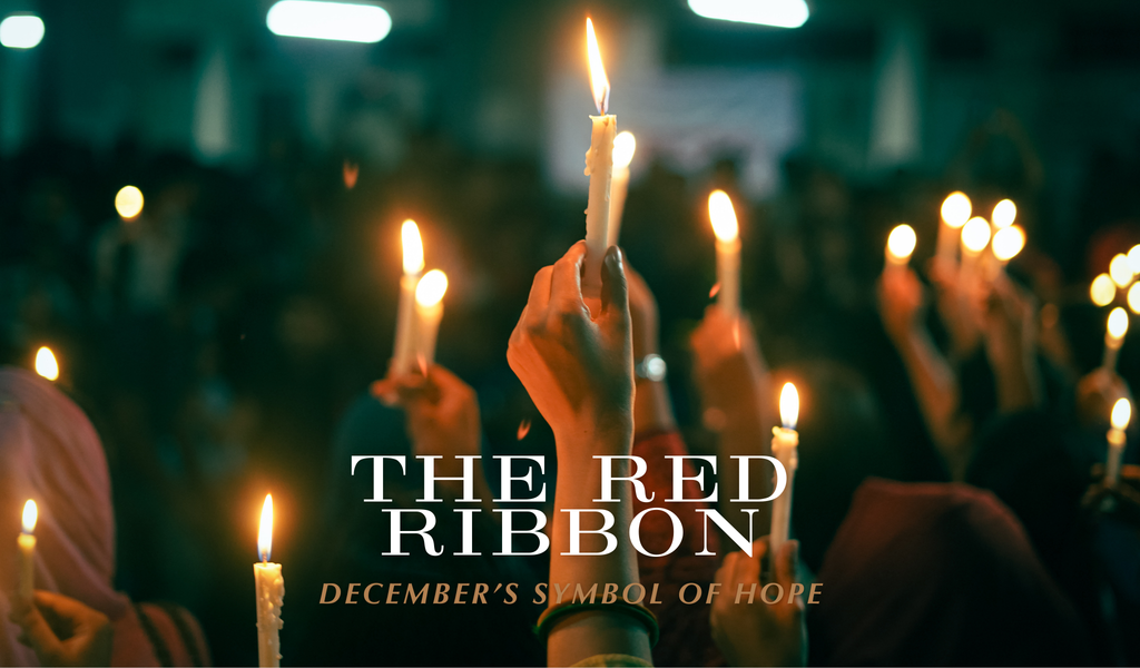 Candlelight vigil with raised candles and text that reads ‘The Red Ribbon – December’s Symbol of Hope.