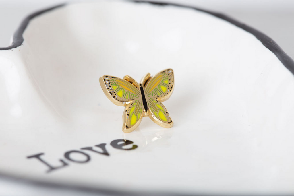 dream maker pins yellow butterfly enamel pin on a ring dish that says love