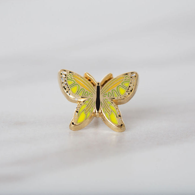 Gold butterfly-shaped jewelry on a light gray background