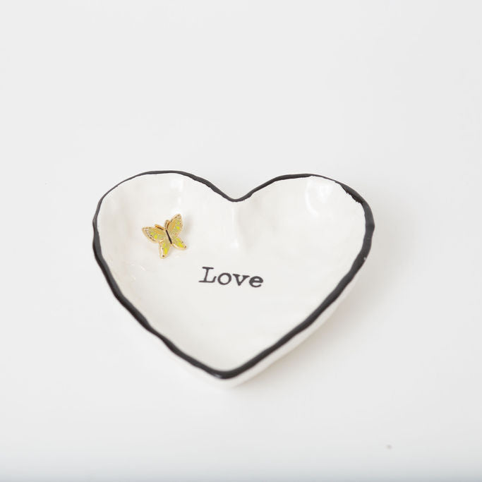Heart-shaped ceramic dish with 'Love' text and a butterfly on a white background
